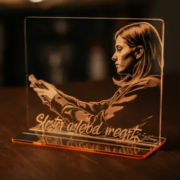 Orange acrylic stand engraved with a woman's portrait and text